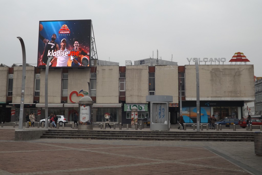 Sur la place principale du centre ville, le logo de Volcano trône. A ses cotés l'imposant écran montre un spot publicitaire pour la même compagnie. 