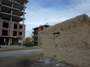 maison en terre et immeuble en construction